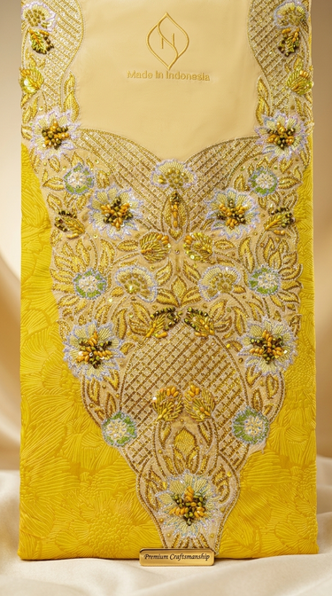 Decorative yellow fabric with intricate gold and white embroidery on a beige background